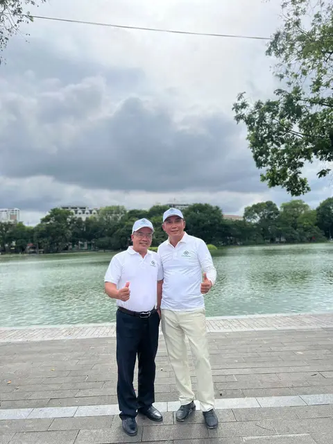 Hai người chụp ảnh cạnh hồ