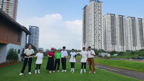 Nhóm trên bãi cỏ, phía sau là toà nhà